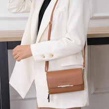 Load image into Gallery viewer, Woman wearing a chic leather shoulder bag with gold accents, complementing a white blazer outfit, showcasing timeless elegance.