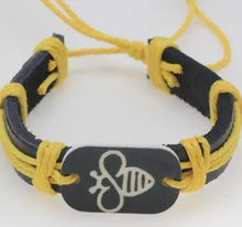 Cargar imagen en el visor de la galería, Thick leather bracelet with engraved stone bee design, featuring yellow accents.