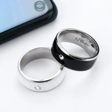 Load image into Gallery viewer, NFC smart rings in black and silver next to a smartphone, showcasing waterproof technology and seamless connectivity.