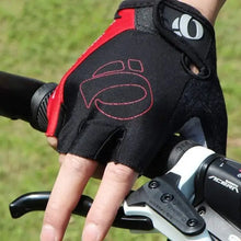 Load image into Gallery viewer, Close-up of a hand wearing black and red cycling gloves gripping bike handlebars. Provides comfort and protection for cyclists.