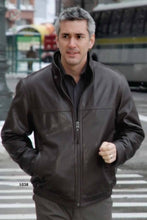 Load image into Gallery viewer, Man wearing a brown WINNERS leather jacket, walking confidently in an urban setting.