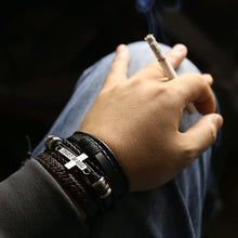Load image into Gallery viewer, Rugged men's leather bracelets add sophistication to casual wear, featuring multiple bangles on wrist, outdoors, hand holding cigarette.