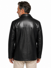 Cargar imagen en el visor de la galería, A man viewed from the back wearing a black leather jacket and light beige pants, photographed against a plain white studio background.