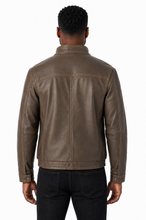 Cargar imagen en el visor de la galería, A man viewed from the back wearing a brown leather jacket and black jeans, photographed against a plain white studio background.