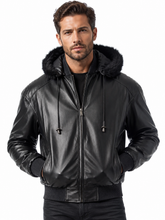 Cargar imagen en el visor de la galería, A man wearing a black faux-leather hooded jacket with a black faux-fur collar, black ribbed knit trim, and a front zipper, photographed against a plain white background.