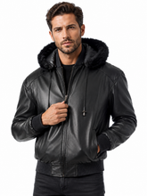 Cargar imagen en el visor de la galería, A man wearing a black faux-leather hooded jacket with a black faux-fur collar, zipped up against a plain white background.