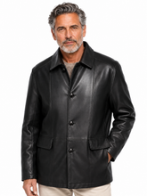 Cargar imagen en el visor de la galería, A man wearing a black leather jacket over a gray shirt and beige pants, photographed against a plain white background.