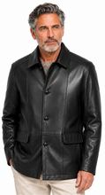 Cargar imagen en el visor de la galería, A man wearing a black leather jacket over a gray shirt and beige pants, photographed against a plain white background.