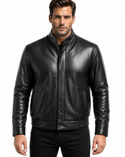 Load image into Gallery viewer, A man wearing a black leather jacket with a stand-up collar, front zipper, and two front flap pockets, photographed against a plain white background.