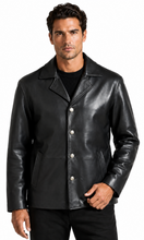 Cargar imagen en el visor de la galería, A man wearing a black leather jacket with silver-tone snap buttons over a black shirt and black pants, photographed against a plain white studio background.