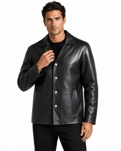 Cargar imagen en el visor de la galería, A man wearing a black leather jacket with silver-tone snap buttons over a black shirt, photographed against a plain white studio background.