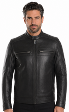 Load image into Gallery viewer, A man wearing a black leather motorcycle jacket with a front zipper, zippered chest pockets, and ribbed cuffs, photographed against a plain white background.