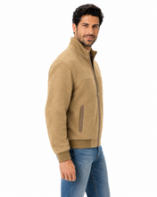 Load image into Gallery viewer, A man wearing a tan suede-like quarter-zip jacket with a stand-up collar and ribbed hem/cuffs, paired with blue jeans, photographed against a plain white background.