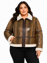 Cargar imagen en el visor de la galería, A woman modeling a brown reptile-embossed faux-leather jacket with a cream sherpa collar, cuffs, and hem, paired with black pants against a plain white background.