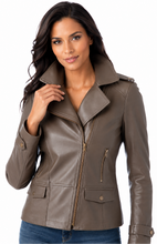 Load image into Gallery viewer, A woman modeling a taupe brown real leather motorcycle jacket with a snap collar, front zipper, and zippered chest pocket, paired with blue jeans against a white background.
