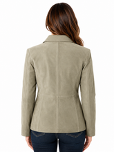 Cargar imagen en el visor de la galería, A woman viewed from the back wearing a light taupe suede blazer and dark blue jeans against a plain white background.