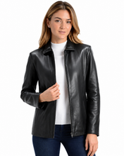 Cargar imagen en el visor de la galería, A woman wearing a black real leather jacket over a white top and dark blue jeans, photographed against a plain white background.