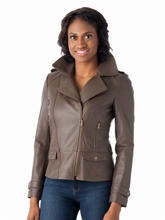Load image into Gallery viewer, A woman wearing a brown real-leather moto jacket with a high collar and front zipper, paired with blue jeans, photographed against a solid white background.