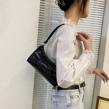 Cargar imagen en el visor de la galería, Woman wearing vegan leather shoulder bag in elegant black, showcasing style and versatility for any occasion.