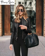 Load image into Gallery viewer, Woman in vegan leather jacket holding a black handbag outdoors.