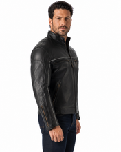 Charger l'image dans la galerie, Black vented leather motorcycle jacket with light reflector, worn by a model. Features air vents and adjustable straps for comfort and safety.