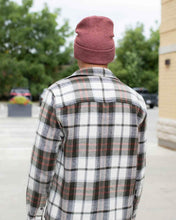 Charger l'image dans la galerie, Rear view of a person wearing a CS105 HAAKWEAR Traditional Silent Cuffed Beanie, Rusty Burgundy, outdoors in a casual setting.