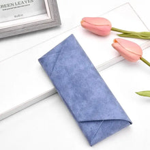Load image into Gallery viewer, Blue PU leather sunglasses case on a table, surrounded by pink tulips. Stylish and compact glasses storage solution.