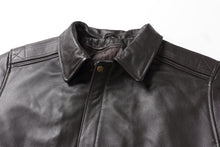 Charger l'image dans la galerie, Close-up of a dark brown textured leather jacket showing the collar, button closure, and shoulder details against a white background.