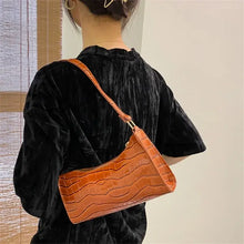 Cargar imagen en el visor de la galería, Person wearing a vegan leather shoulder bag with a crocodile texture, showcasing elegance and versatility.