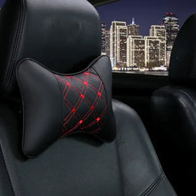 Load image into Gallery viewer, PU leather car neck pillow with red stitching on car seat, providing comfort for head pain relief, against city skyline background.