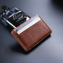 Load image into Gallery viewer, Minimalist vegan leather wallet with multiple compartments, shown on dark surface, next to a bottle of perfume.