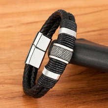 Load image into Gallery viewer, Woven leather rope and stainless steel men's bracelet on wooden surface, showcasing high-quality craftsmanship.