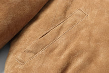 Load image into Gallery viewer, Close-up of REED Men's Baseball Suede Leather Jacket in soft tan fabric with detailed stitching and side pocket design.