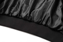 Load image into Gallery viewer, Close-up of black satin lining and elastic hem on a suede leather jacket.