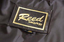 Load image into Gallery viewer, Label of REED Men's New Zealand Lambskin Leather Jacket showing brand logo, crafted in fine lambskin leather, black color.