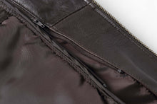 Load image into Gallery viewer, Close-up of the interior zipper and leather detailing on a REED Men's New Zealand Lambskin Leather Jacket in black.