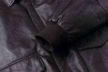 Load image into Gallery viewer, Close-up of REED Men's Premium Leather Aviator Bomber Jacket showing durable leather, sleeve cuff, and front pocket details. Stylish & comfortable.
