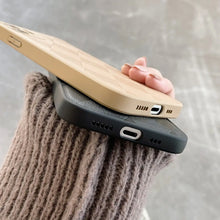 Cargar imagen en el visor de la galería, Person holding two slim retro leather phone cases in beige and black.