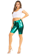 Charger l'image dans la galerie, Model wearing shiny metallic green bike shorts with white crop top and clear heels, showcasing stretchy unisex fit, made in USA.