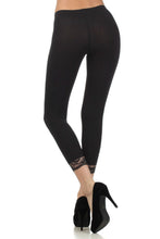 Load image into Gallery viewer, Woman wearing black cotton blend lace trim stretch capri leggings with heels, suitable for yoga, pilates, or casual wear.