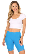 Charger l'image dans la galerie, Woman modeling blue cotton blend lace trim bike shorts with white crop top.