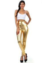 Charger l'image dans la galerie, Model wearing shiny liquid metallic high waist stretch leggings in gold, made in USA, paired with a white crop top and black heels.