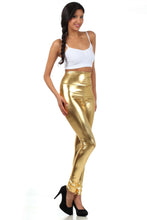 Charger l'image dans la galerie, Woman wearing shiny liquid metallic high waist stretch leggings in gold, paired with white top and black heels.