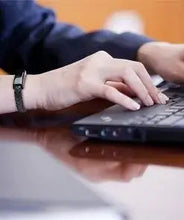 Cargar imagen en el visor de la galería, USB leather charging braided bracelet on wrist typing on laptop