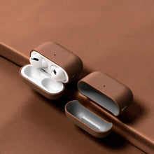 Load image into Gallery viewer, Brown genuine leather AirPods case with AirPods inside, showcasing snug fit and durable protection on a matching surface.