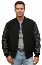 Cargar imagen en el visor de la galería, Man wearing a black varsity jacket over a gray t-shirt with text on a white background