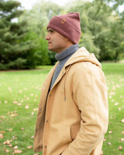 Charger l'image dans la galerie, Man wearing NEW HAAKWEAR H-Stitch Cuffed Beanie - Designed and Made in USA (Patented Design) - Rusty Burgundy in a park setting.