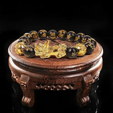 Load image into Gallery viewer, Feng Shui Wealth Bracelet with Black Beads and Gold Pixiu Charm on Wooden Stand for Prosperity and Luck