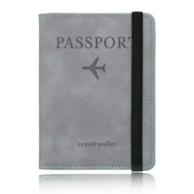 Load image into Gallery viewer, Grey leather passport holder travel wallet with RFID-blocking technology, featuring a secure strap and airplane design for stylish travel.