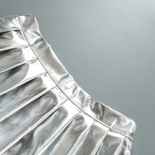 Cargar imagen en el visor de la galería, Sleek pleated faux leather mini skirt in metallic silver, showcasing chic and sophisticated design.